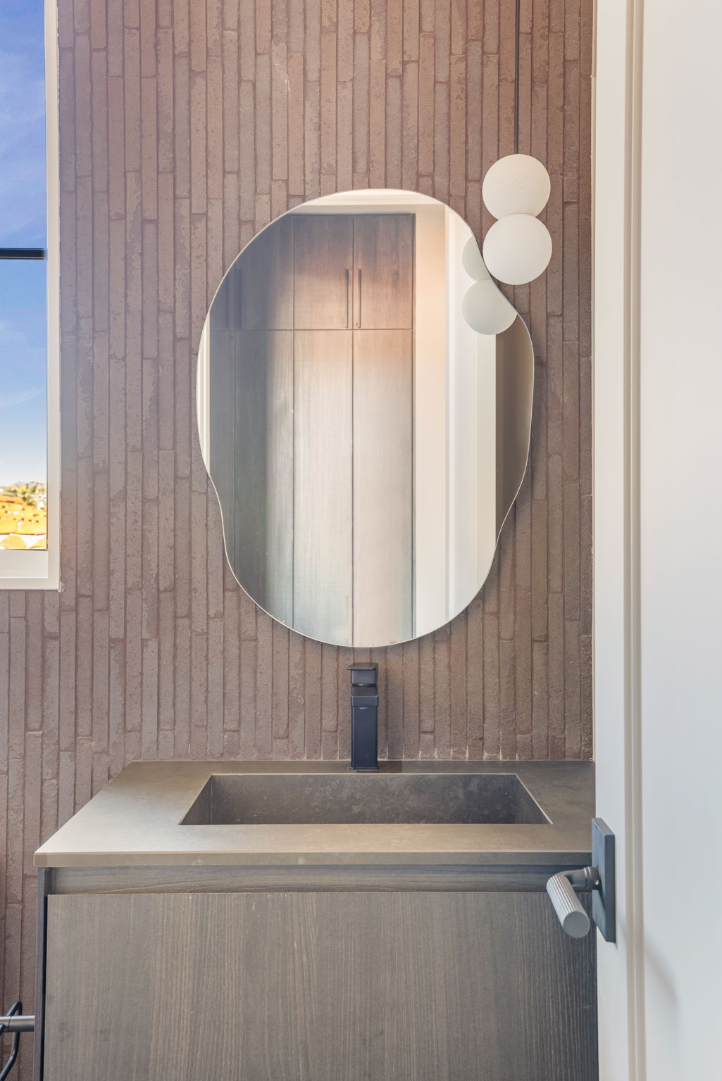 The Alder House guest bath with ribbed clay tile and round mirror