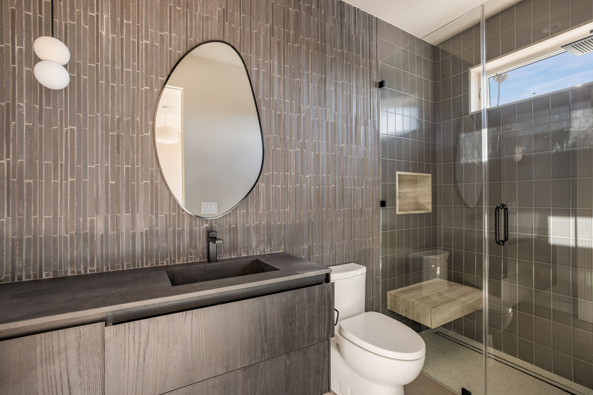 The Alder House guest bath with ribbed grey tile and glass shower