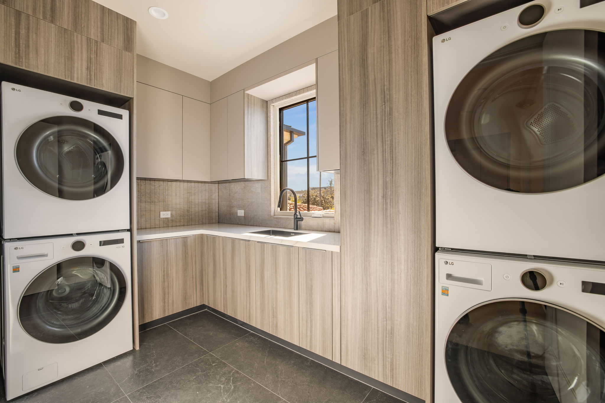 The Alder House laundry room with stacked LG washers and dryers