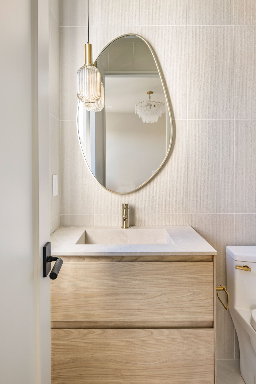 The Alder House primary bath vanity with oval brass mirror