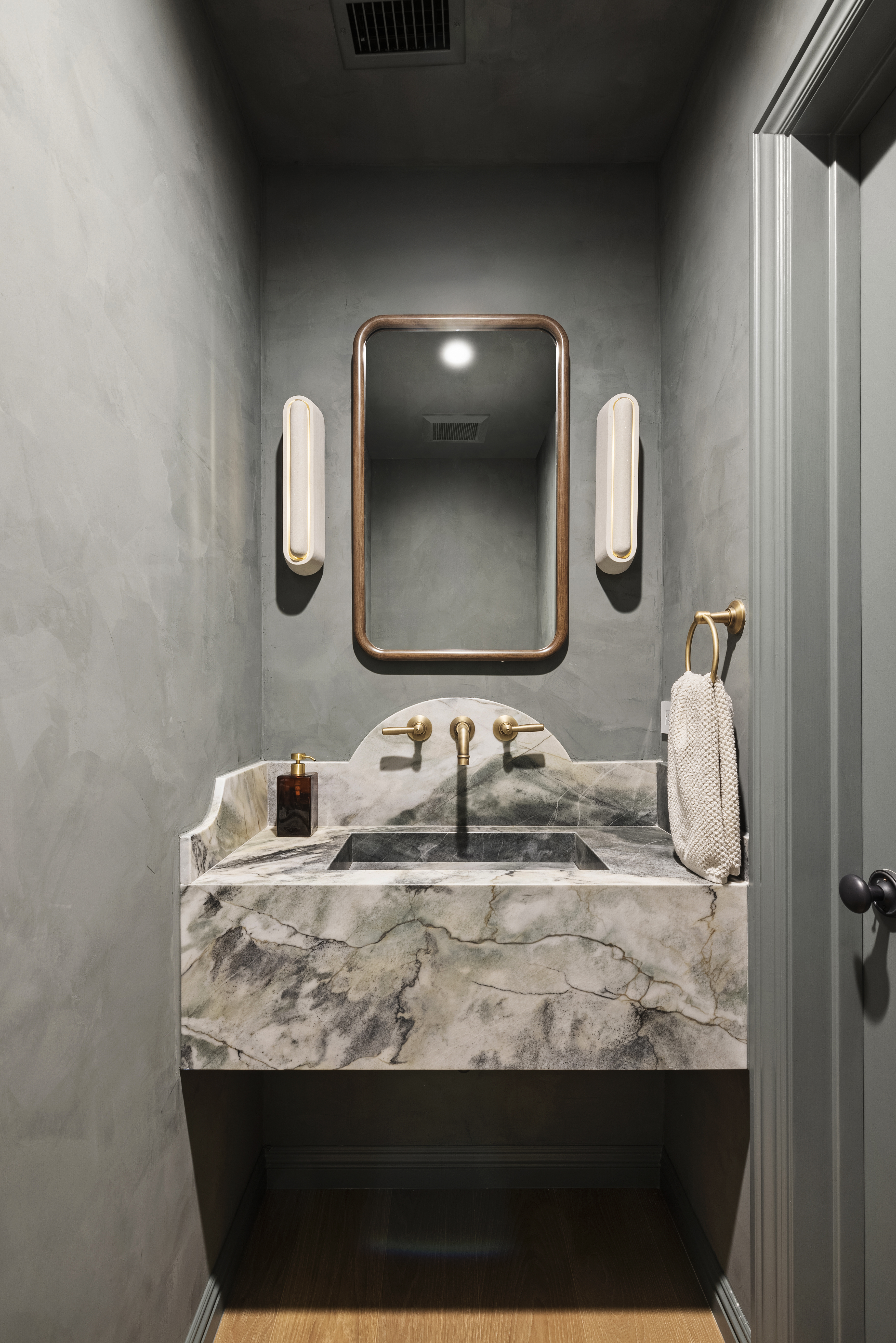 Casa Lista powder room with dark plaster walls and marble sink