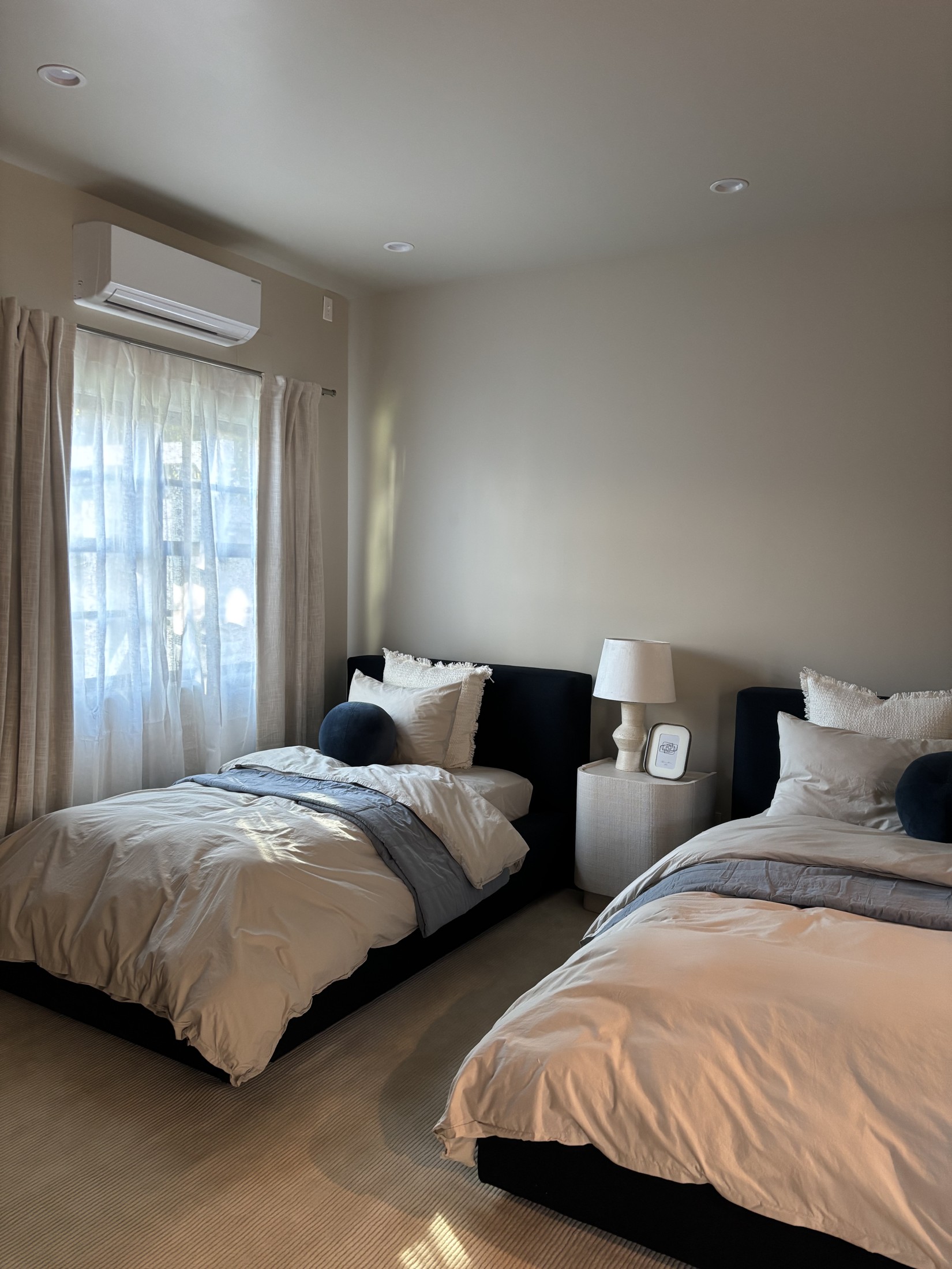 The Coach House twin bedroom with black upholstered bed frames