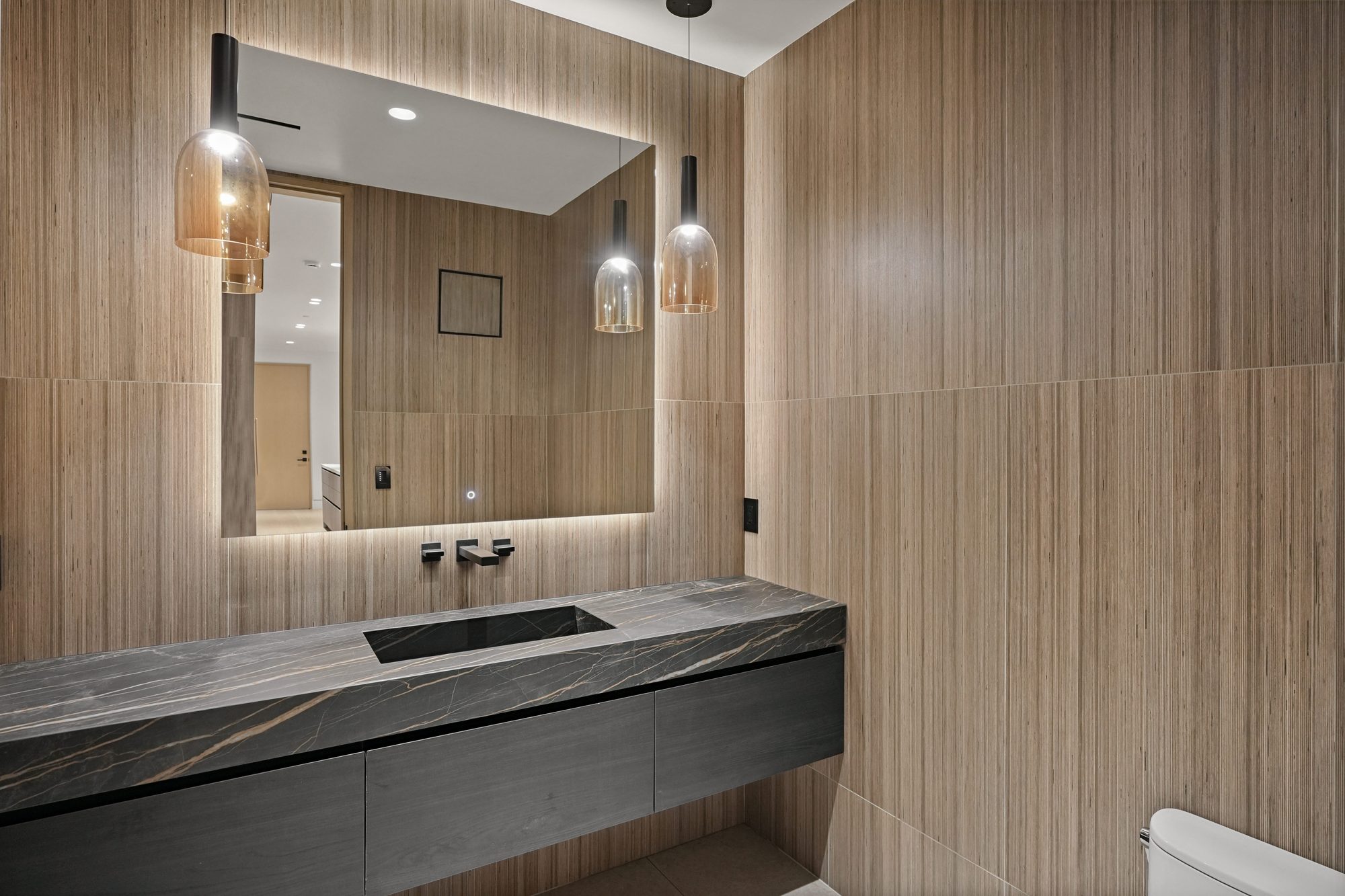 The Form House primary bath with black fixtures and glass shower