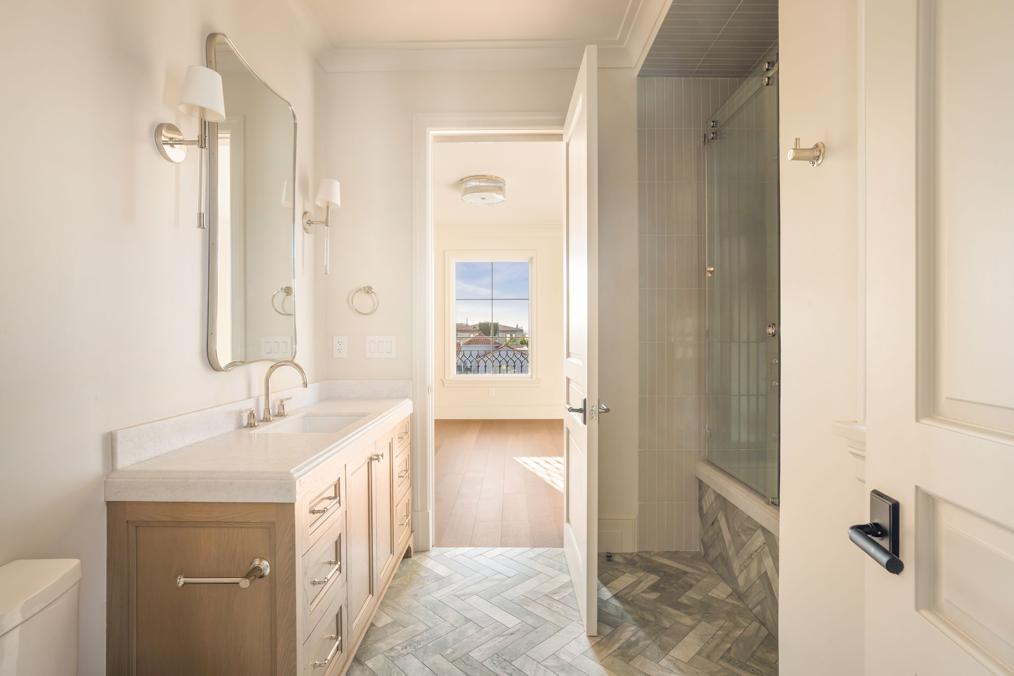 The Magnolia House guest bath with herringbone tile floor