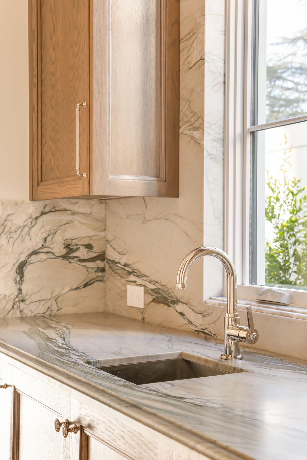 The Magnolia House kitchen faucet and marble backsplash detail