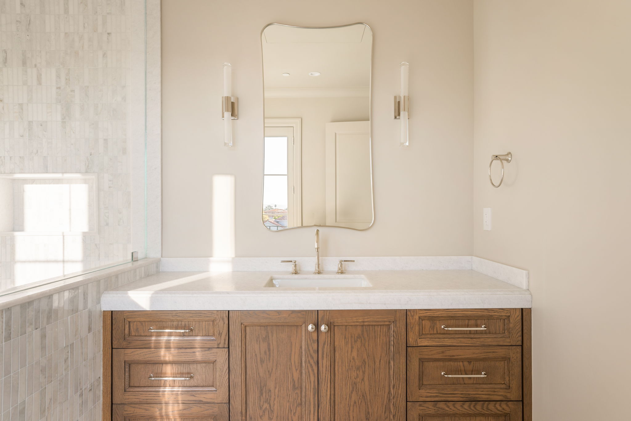 The Magnolia House primary bath vanity with scalloped mirror