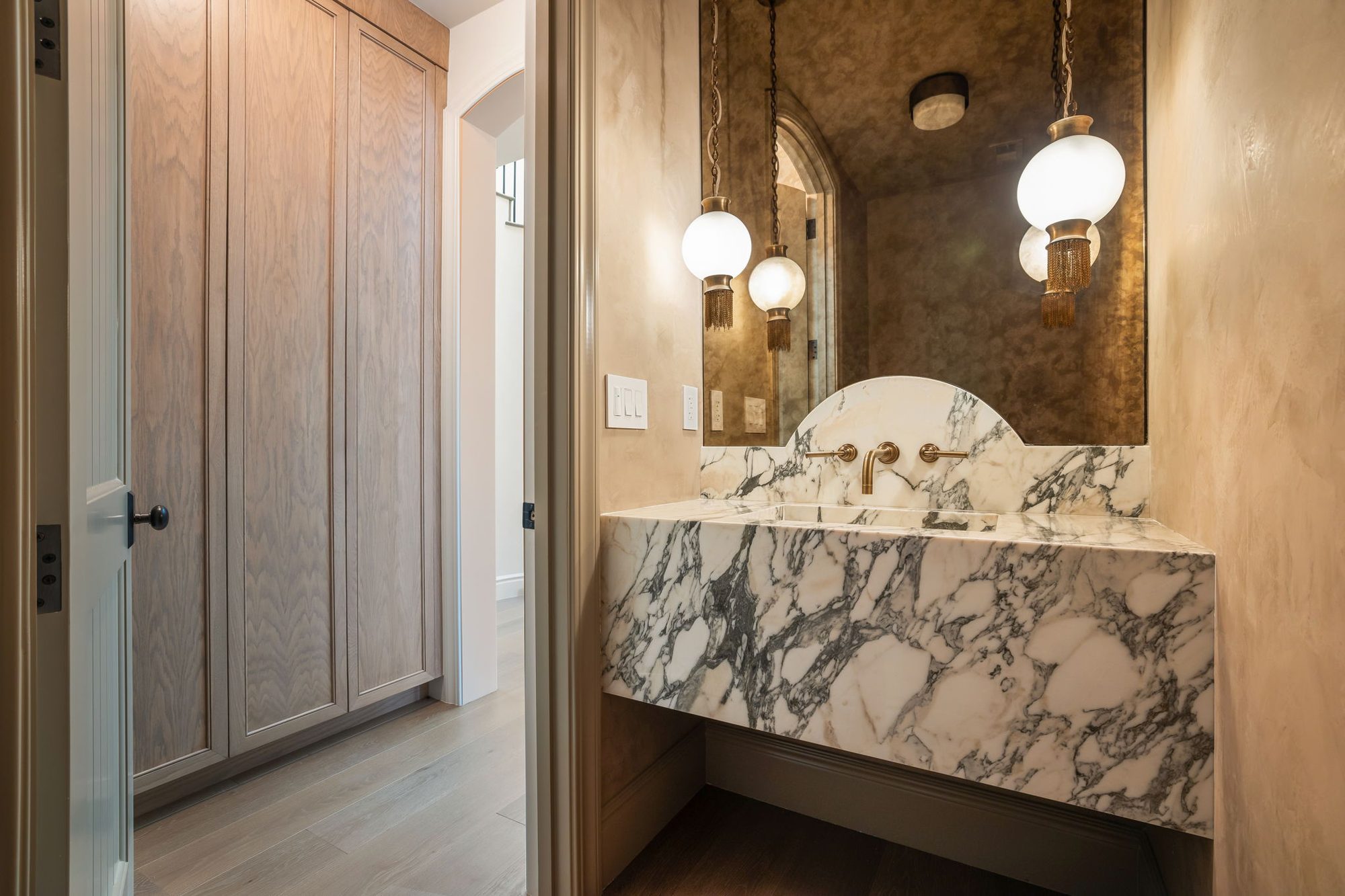 Storybook House powder room with antiqued mirror and marble vanity