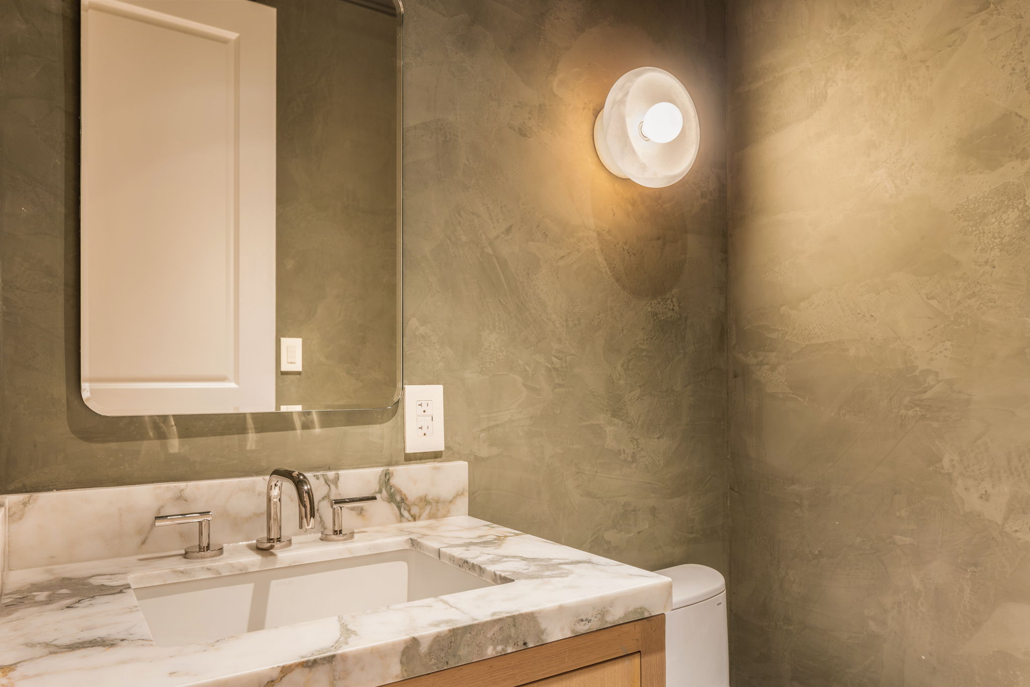 The Thistle House powder room with olive plaster walls
