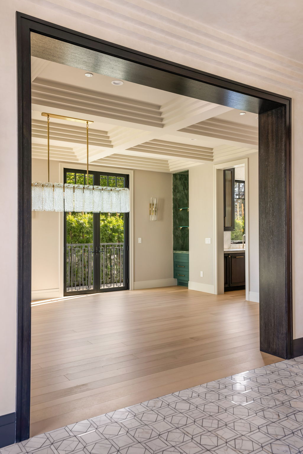 The Verdigris House dining room with coffered ceiling and linear chandelier