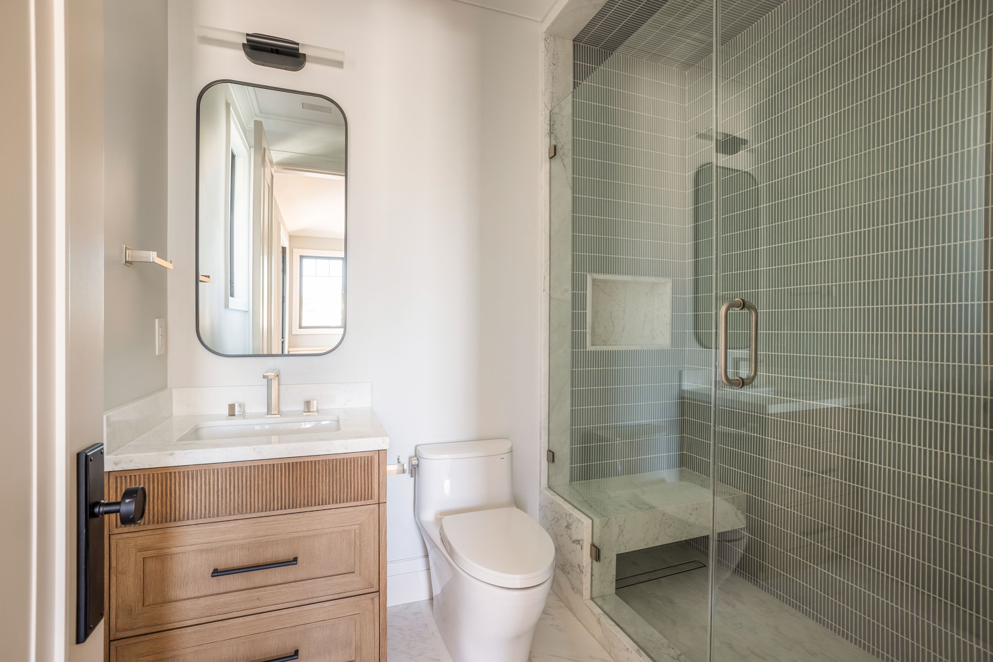 The Verdigris House guest bath with sage mosaic tile shower