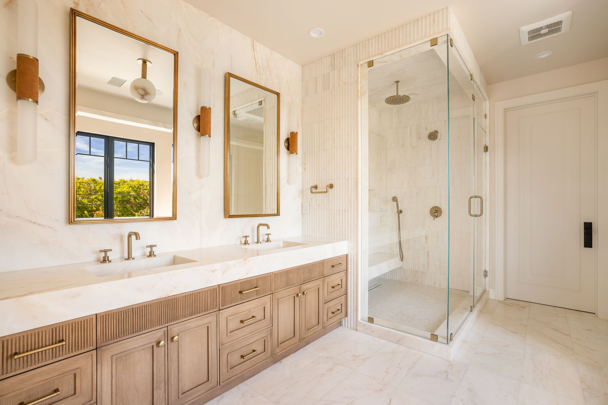 The Verdigris House primary bath double vanity with brass-framed mirrors